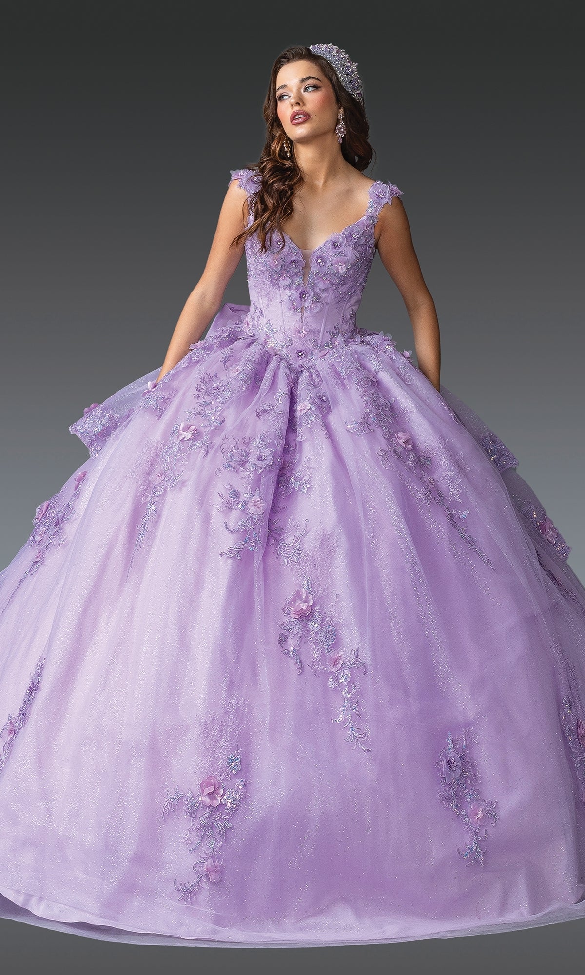 A woman in the Quinceanera Dress 1952 By Dancing Queen, featuring lilac floral lace embroidery and a matching headpiece, stands against a plain gradient background.